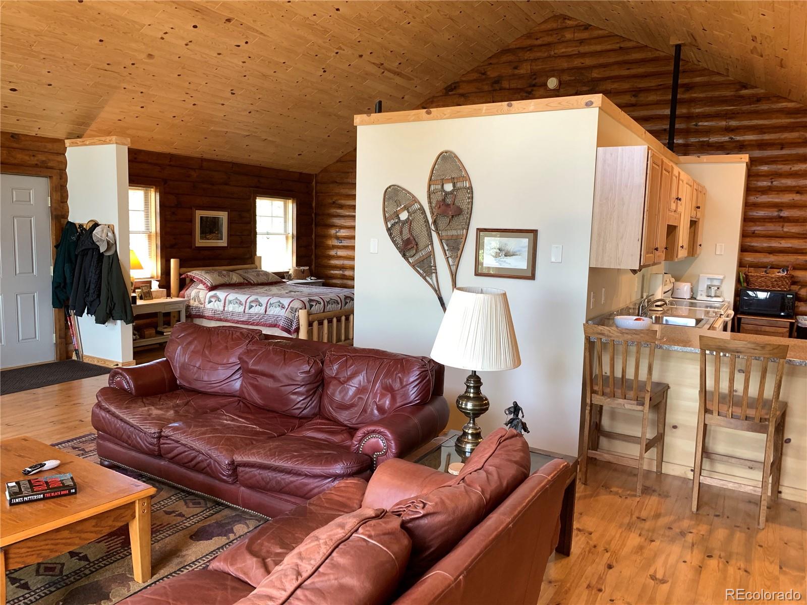 1866 Bellows Road Hartsel, CO 80449 - Photo 34 of 38 a living room with furniture a flat screen tv and a floor to ceiling window