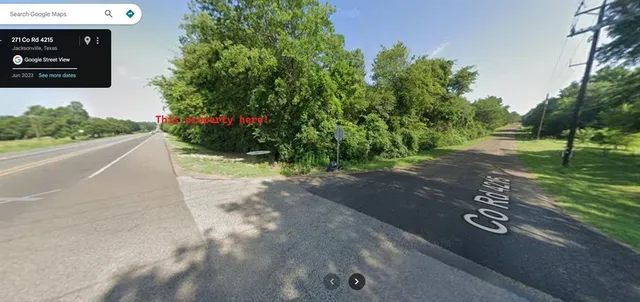 a view of a street with a bench and trees