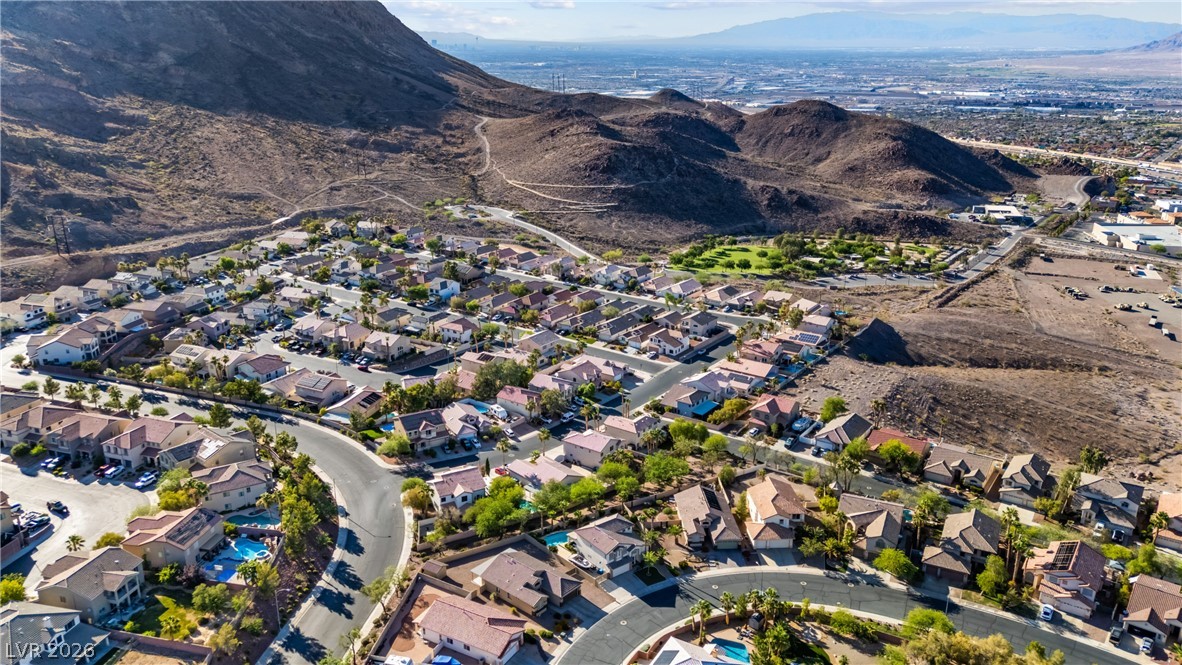 708 Vortex Avenue Henderson, NV 89002 - Photo 63 of 71 An aerial perspective reveals a vibrant neighborhood nestled against rugged hillsides.