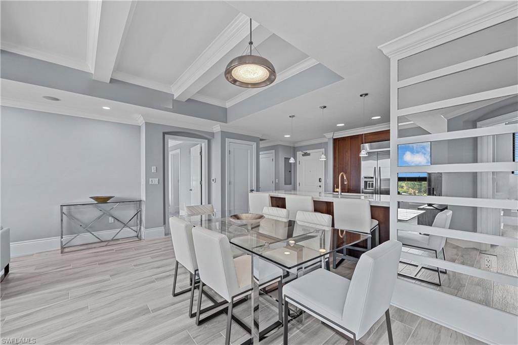 9115 Strada Place, Unit 5511 Naples, FL 34108 - Photo 11 of 38 a view of a dining room with furniture and a book shelf