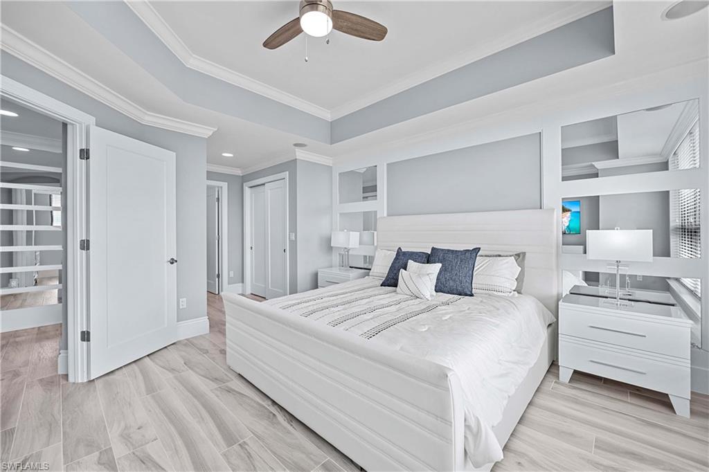 9115 Strada Place, Unit 5511 Naples, FL 34108 - Photo 13 of 38 a bedroom with a bed and a chandelier