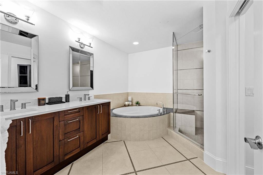 9115 Strada Place, Unit 5511 Naples, FL 34108 - Photo 14 of 38 a bathroom with a toilet a sink a mirror and a shower