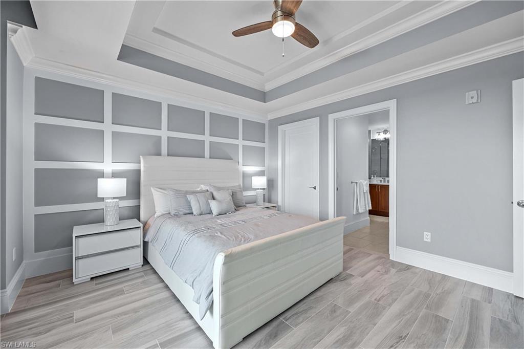 9115 Strada Place, Unit 5511 Naples, FL 34108 - Photo 18 of 38 a bedroom with a bed and a chandelier