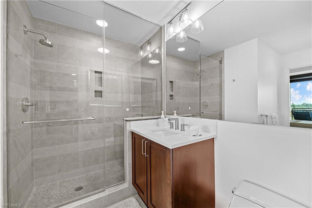 9115 Strada Place, Unit 5511 Naples, FL 34108 - Photo 19 of 38 a bathroom with a sink a shower a mirror and a shower