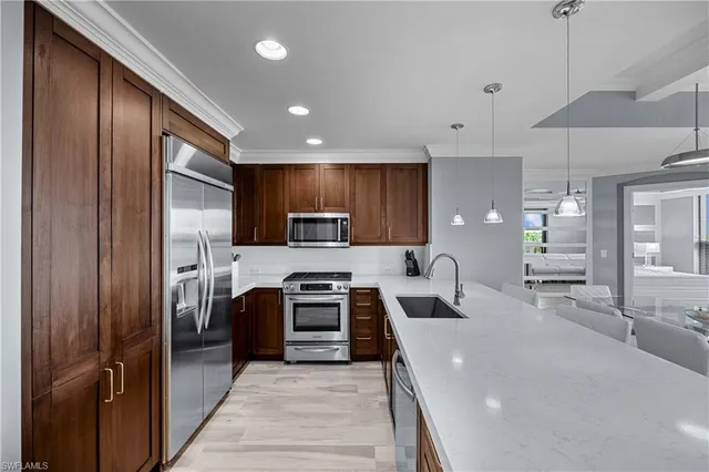 a kitchen with stainless steel appliances granite countertop wooden cabinets a stove top oven a sink and dishwasher