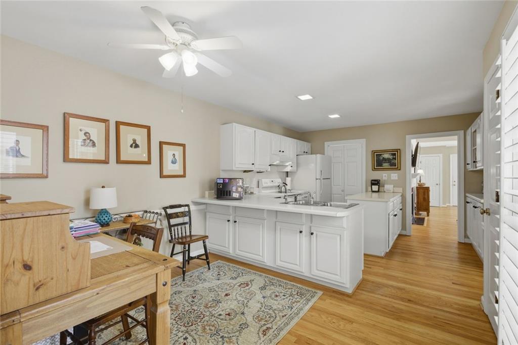 3269 Embry Downs Court Atlanta, GA 30340 - Photo 14 of 38 a large white kitchen with wooden floor and a sink