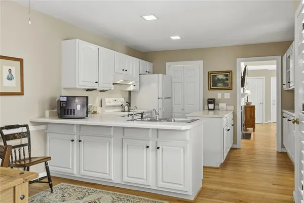 a kitchen with white cabinets and sink