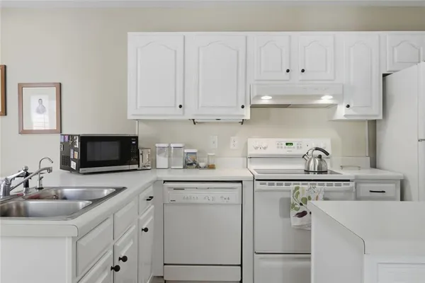 a kitchen with cabinets appliances a sink and a counter top