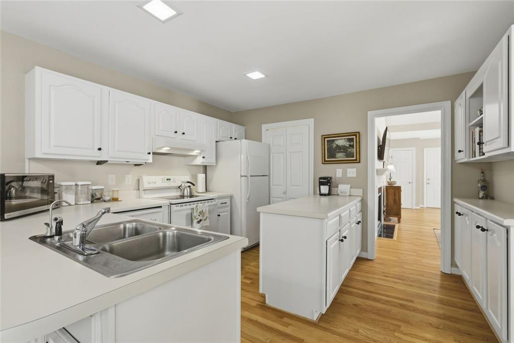 3269 Embry Downs Court Atlanta, GA 30340 - Photo 17 of 38 a kitchen with white cabinets sink and stainless steel appliances