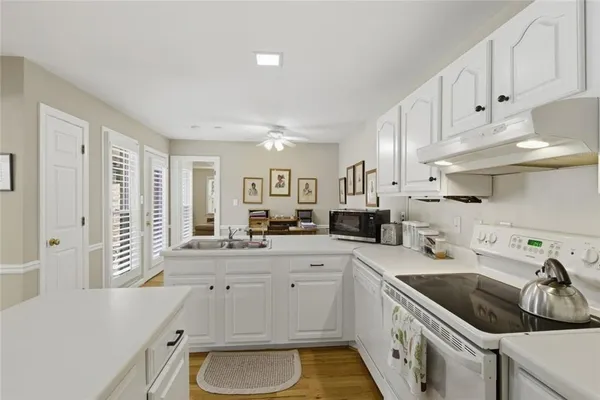 a kitchen with granite countertop a sink a stove and cabinets