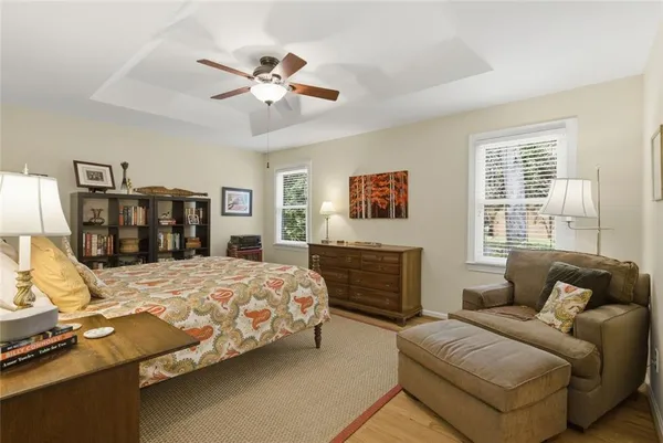a bedroom with a large bed two couches and a flat tv screen