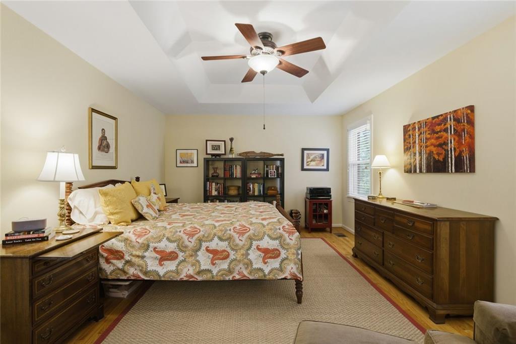 3269 Embry Downs Court Atlanta, GA 30340 - Photo 22 of 38 a bedroom with a large bed and a chandelier