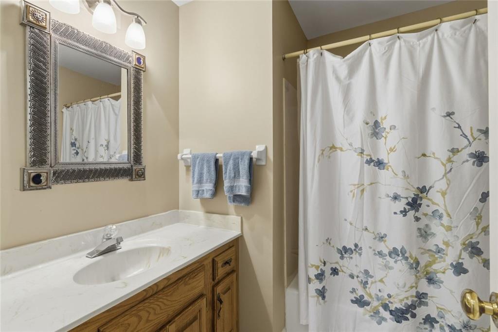 3269 Embry Downs Court Atlanta, GA 30340 - Photo 28 of 38 a bathroom with a granite countertop sink a mirror and shower curtain