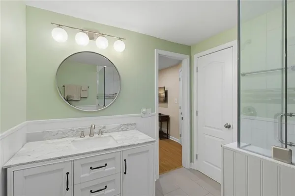 a bathroom with a granite countertop sink a mirror and a shower