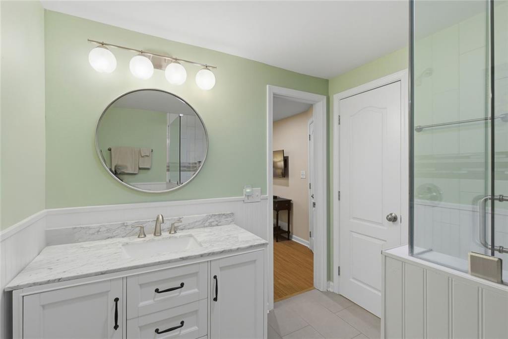 3269 Embry Downs Court Atlanta, GA 30340 - Photo 34 of 38 a bathroom with a granite countertop sink a mirror and a shower