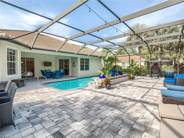 a view of a patio with table and chairs under an umbrella