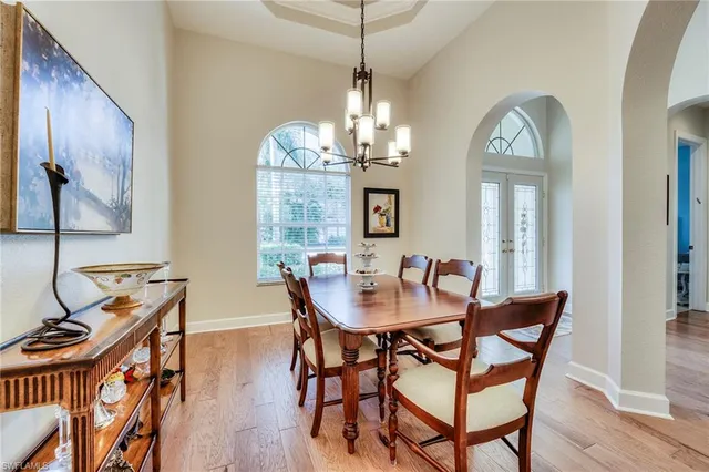 a view of a dining room with furniture a chandelier and wooden floor