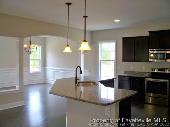 101 Caulfield Road Aberdeen, NC 28315 - Photo 3 of 19 a kitchen with stainless steel appliances granite countertop a sink a stove and a wooden floors