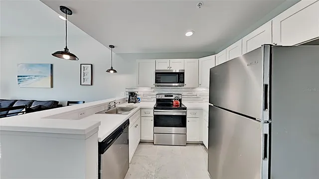 a kitchen with stainless steel appliances a refrigerator sink and microwave