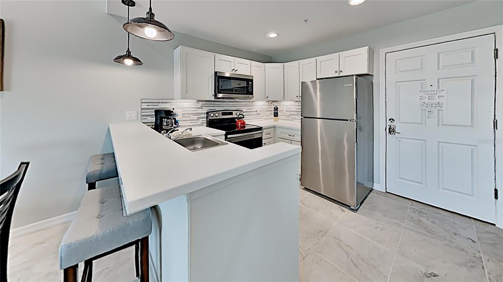 13101 Gulf Boulevard, Unit 1506 Madeira Beach, FL 33708 - Photo 6 of 15 a kitchen with stainless steel appliances a refrigerator stove and microwave
