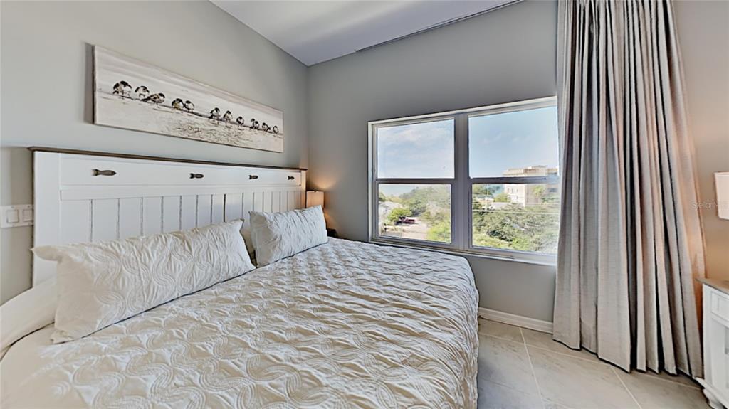 13101 Gulf Boulevard, Unit 1506 Madeira Beach, FL 33708 - Photo 9 of 15 a bedroom with a bed and a window