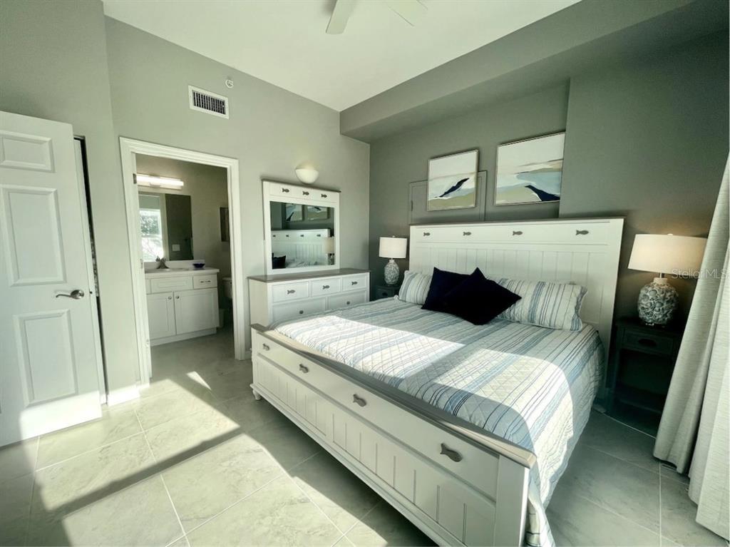13101 Gulf Boulevard, Unit 1506 Madeira Beach, FL 33708 - Photo 10 of 15 a bedroom with a bed and large mirror