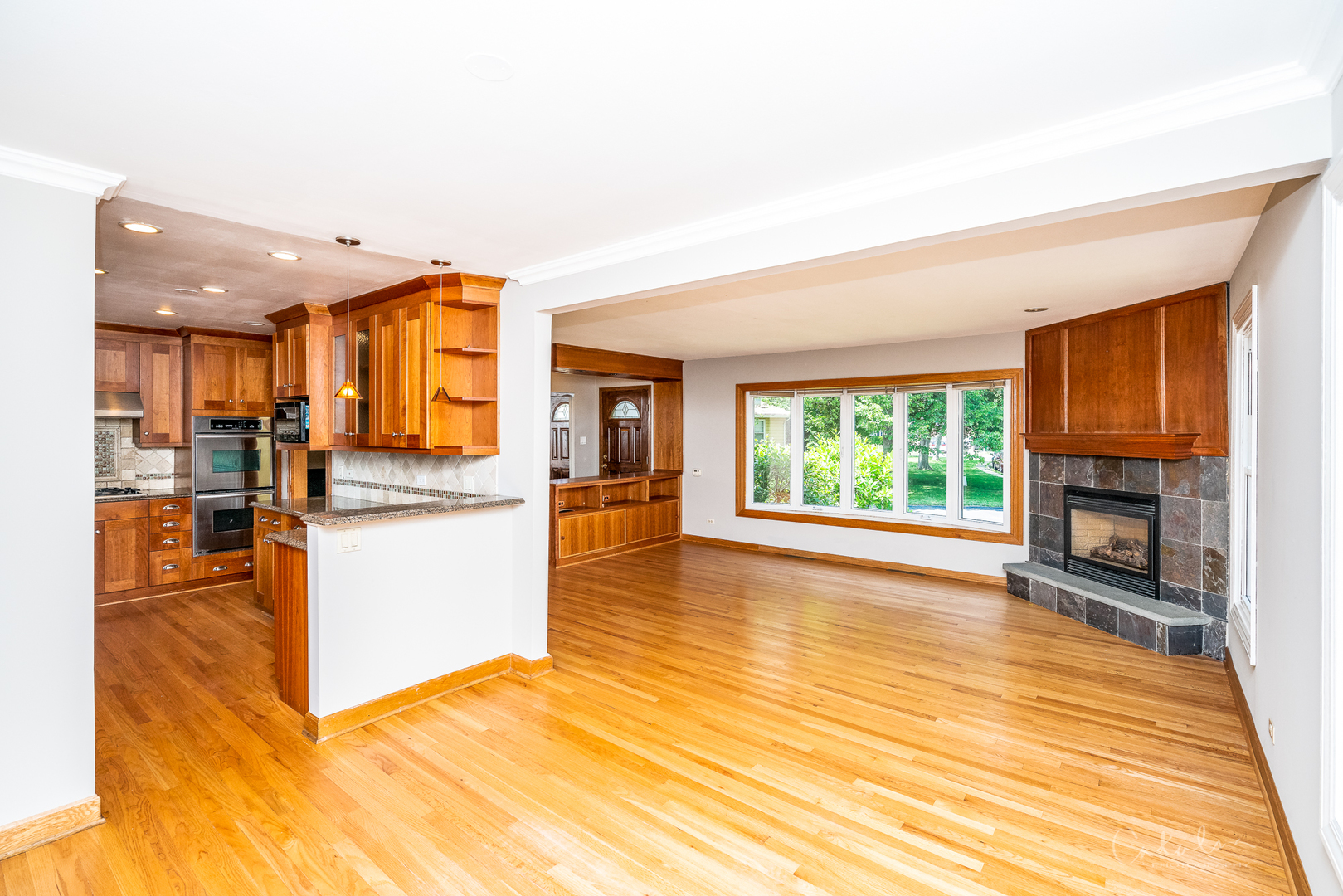 1415 Charing Cross Road Deerfield, IL 60015 - Photo 12 of 23 a view of open kitchen with kitchen island wooden cabinets and living room