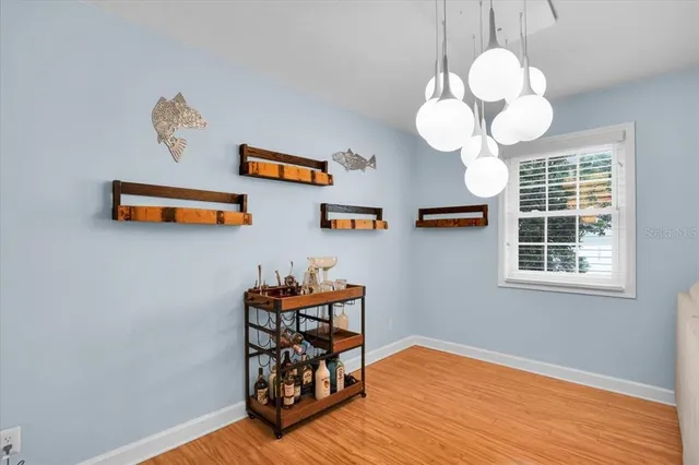 a view of a dining room with wooden floor and chandelier