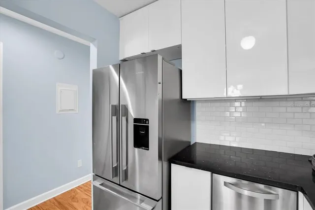 a kitchen with granite countertop a refrigerator and a stove top oven