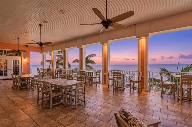 a outdoor space with lots of tables a chandelier and pool