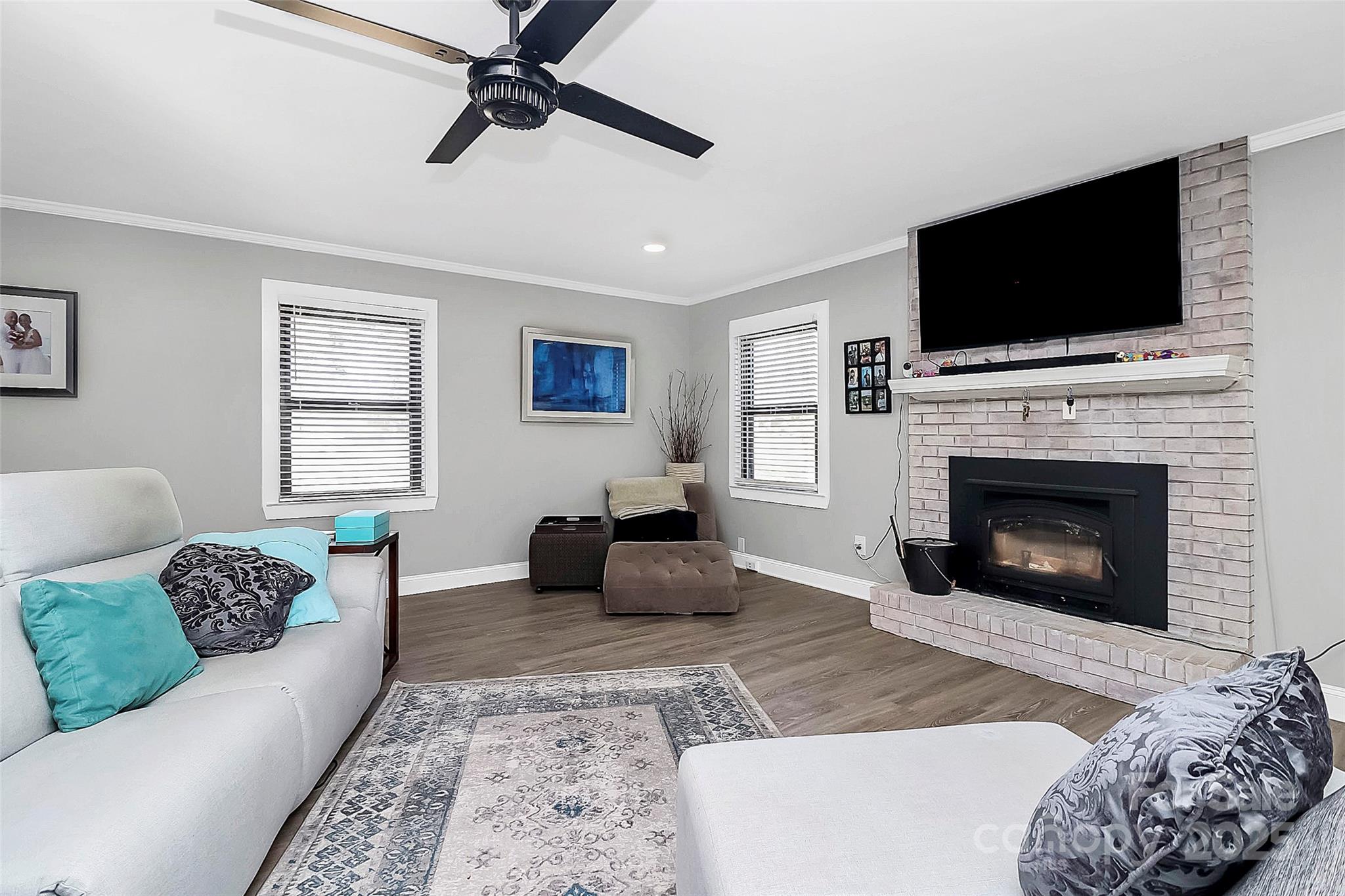 9808 Washam Potts Road Cornelius, NC 28031 - Photo 17 of 43 a living room with furniture a fireplace and a flat screen tv