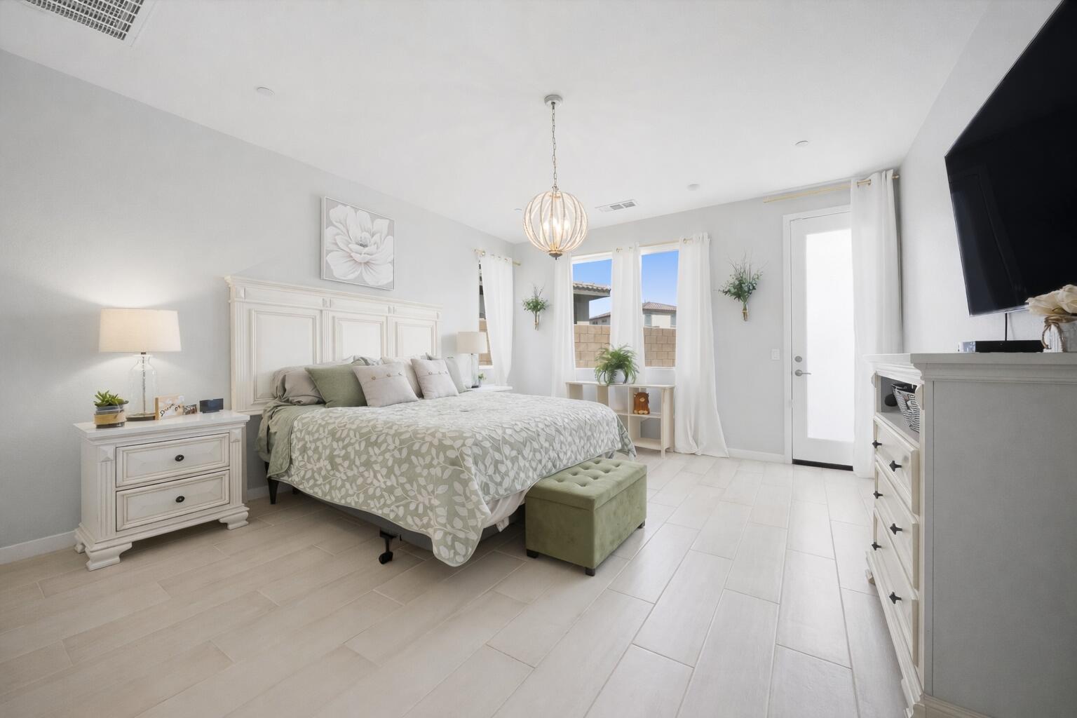 40340 Vivaldi Court Indio, CA 92203 - Photo 17 of 30 a spacious bedroom with a bed and a flat tv screen on dresser