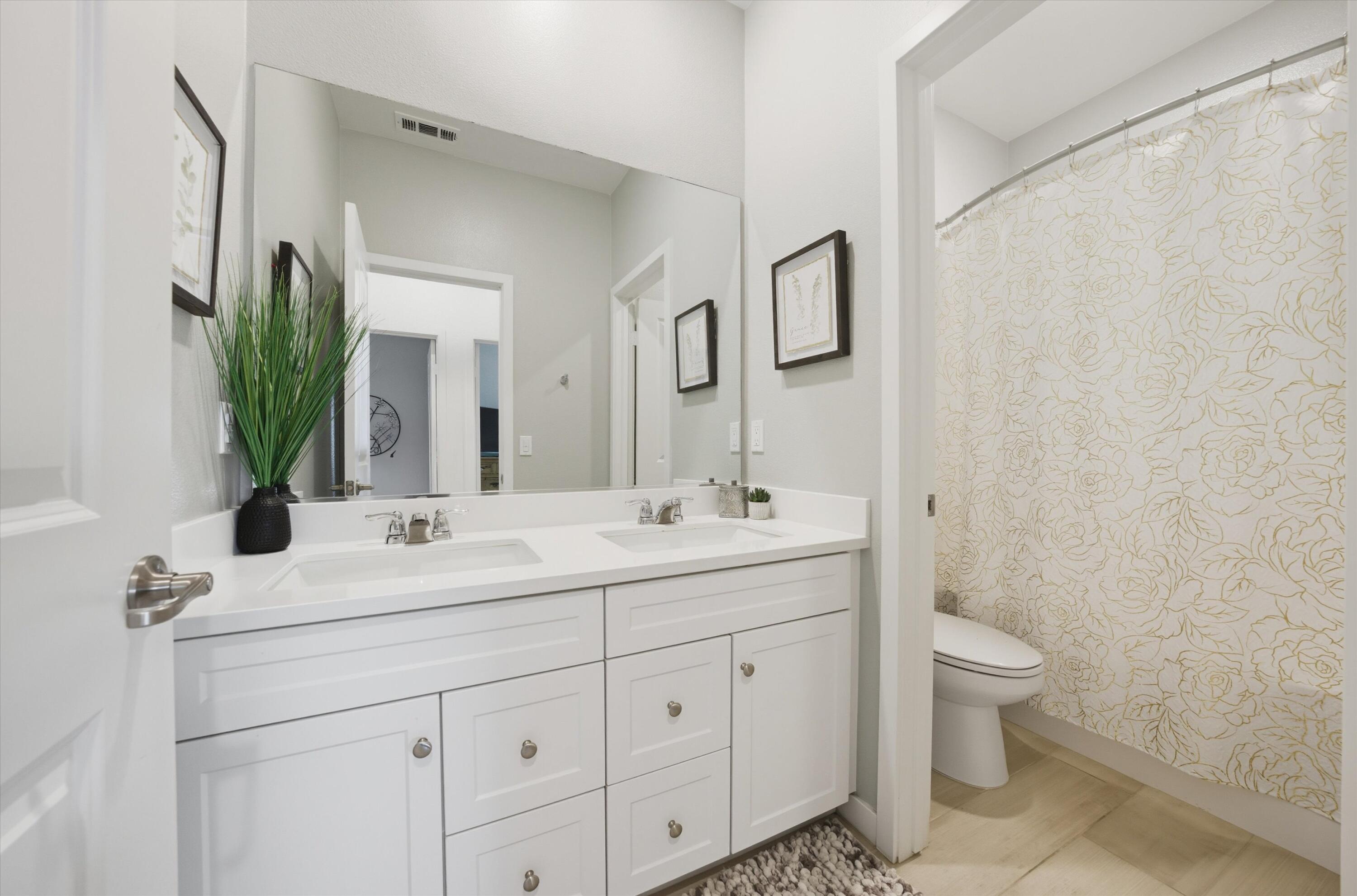 40340 Vivaldi Court Indio, CA 92203 - Photo 22 of 30 a bathroom with a double vanity sink toilet and mirror