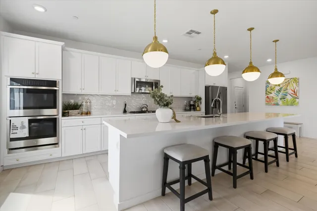 a kitchen with a sink kitchen island and stainless steel appliances