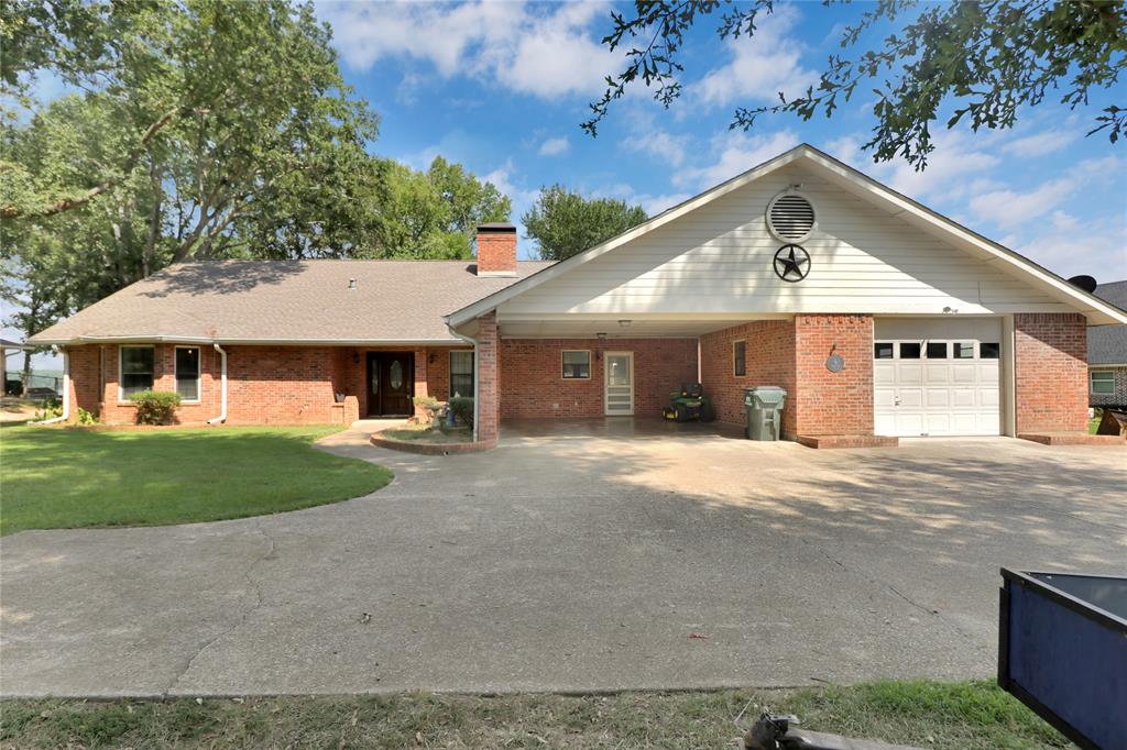 16223 Big Oak Bay Road Tyler, TX 75707 - Photo 9 of 30 Ranch-style home with asphalt driveway, a carport, a chimney, brick siding, and a porch