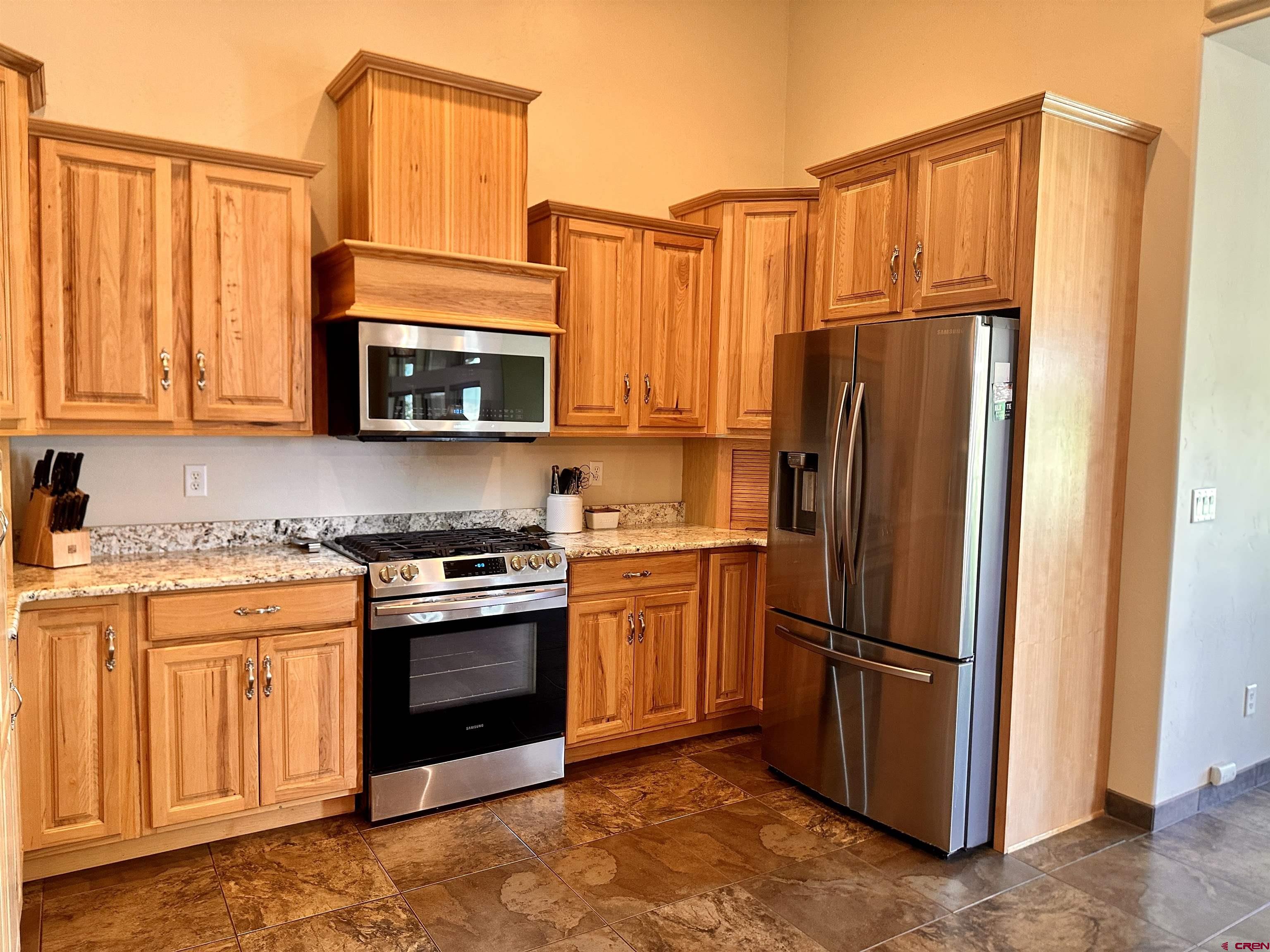 1889 Snaffle Bit Road Delta, CO 81416 - Photo 8 of 45 a kitchen with stainless steel appliances granite countertop a refrigerator a stove a sink and a microwave