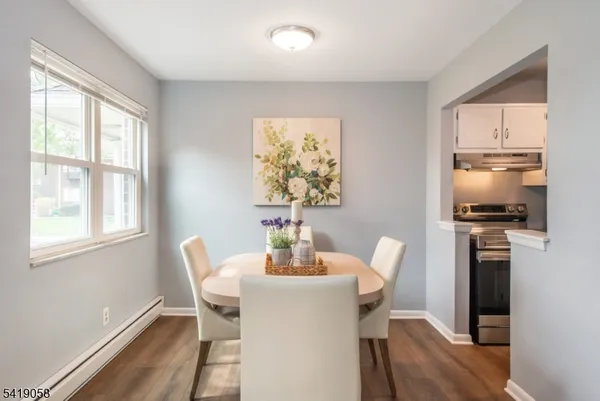 a view of a dining room with furniture a chandelier and wooden floor