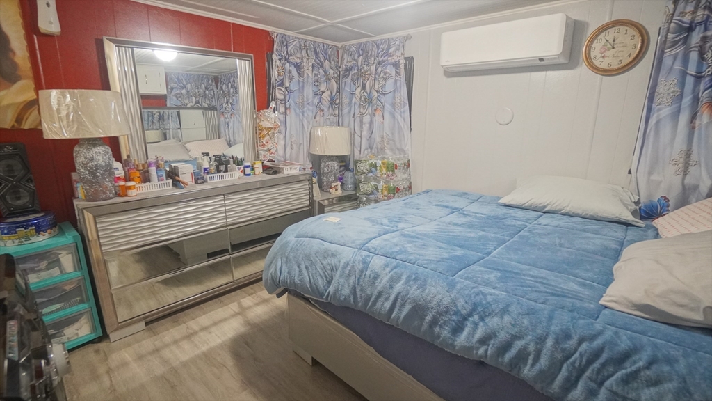 93 Grochmal Avenue, Unit 126 Springfield, MA 01151 - Photo 34 of 35 a bedroom with a bed and a table with wooden floor