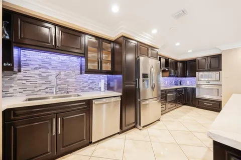 a kitchen with stainless steel appliances a refrigerator and a counter top space