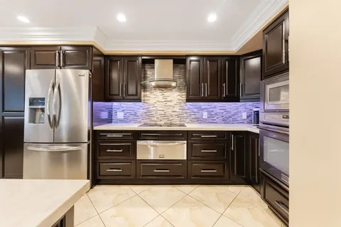a kitchen with stainless steel appliances granite countertop a refrigerator and a stove top oven
