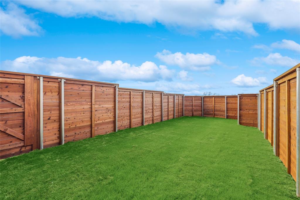 1604 Casting Ridge Mesquite, TX 75181 - Photo 37 of 38 Private backyard featuring a well-maintained lawn and horizontal plank wood fencing with metal posts
