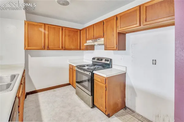 a kitchen with stainless steel appliances granite countertop a sink a stove and a refrigerator