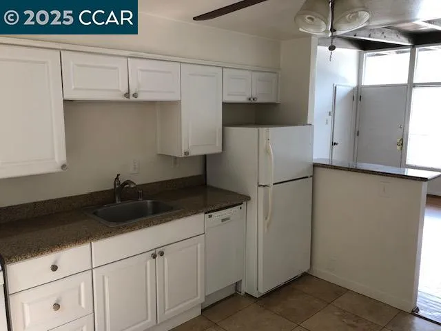 a view of a refrigerator in kitchen and a window