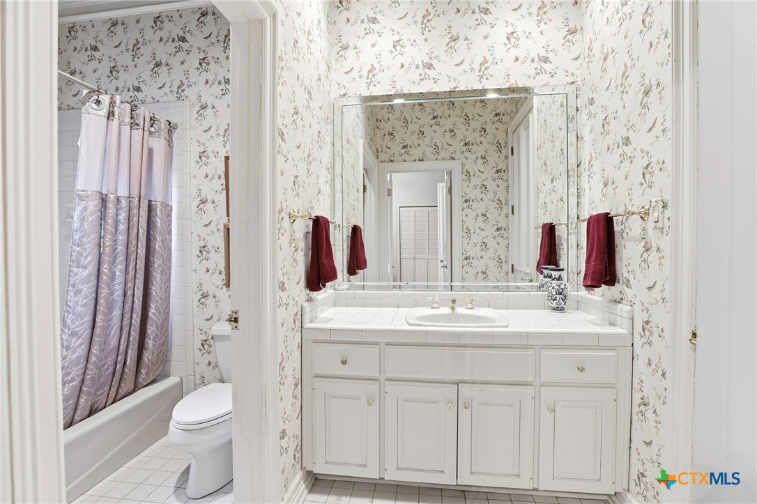 21759 Forest Waters Circle Garden Ridge, TX 78266 - Photo 15 of 30 a bathroom with a sink a toilet and shower curtain