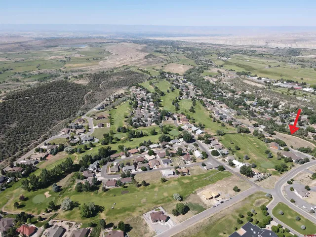 an aerial view of ocean and residential houses with outdoor space