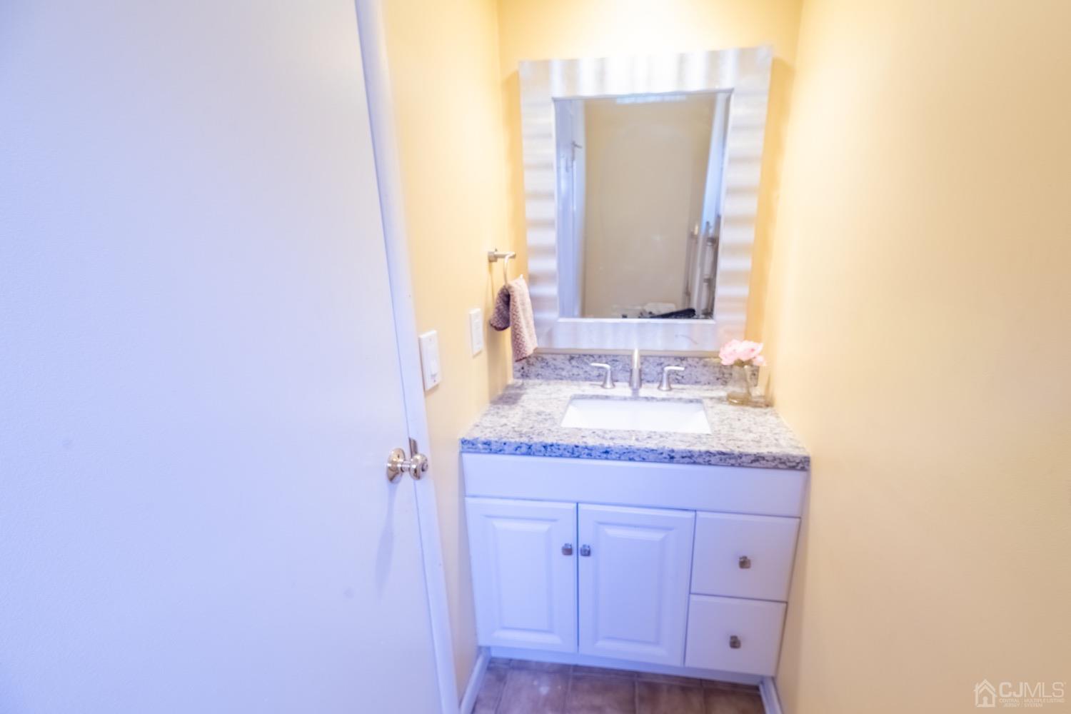 4602 Stonehedge Road Edison, NJ 08820 - Photo 11 of 87 a bathroom with a granite countertop sink and a mirror