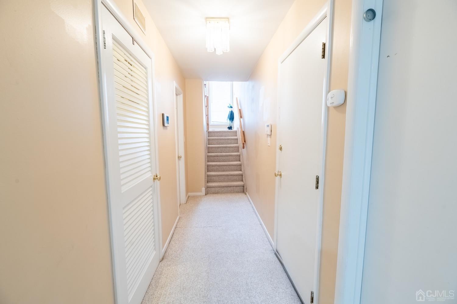 4602 Stonehedge Road Edison, NJ 08820 - Photo 16 of 87 a view of a hallway with wooden floor and staircase