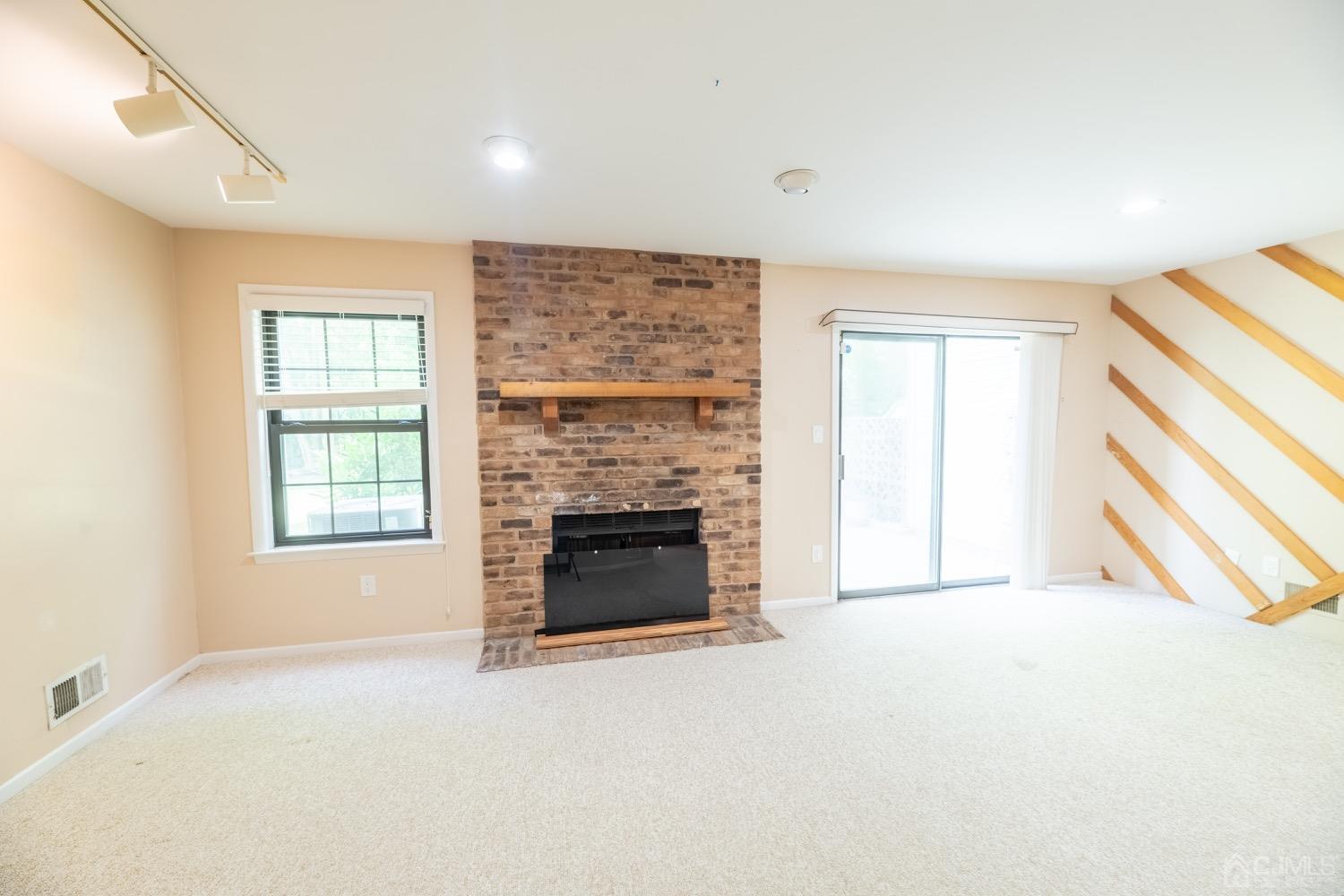 4602 Stonehedge Road Edison, NJ 08820 - Photo 21 of 87 a view of an empty room with a fireplace and a window