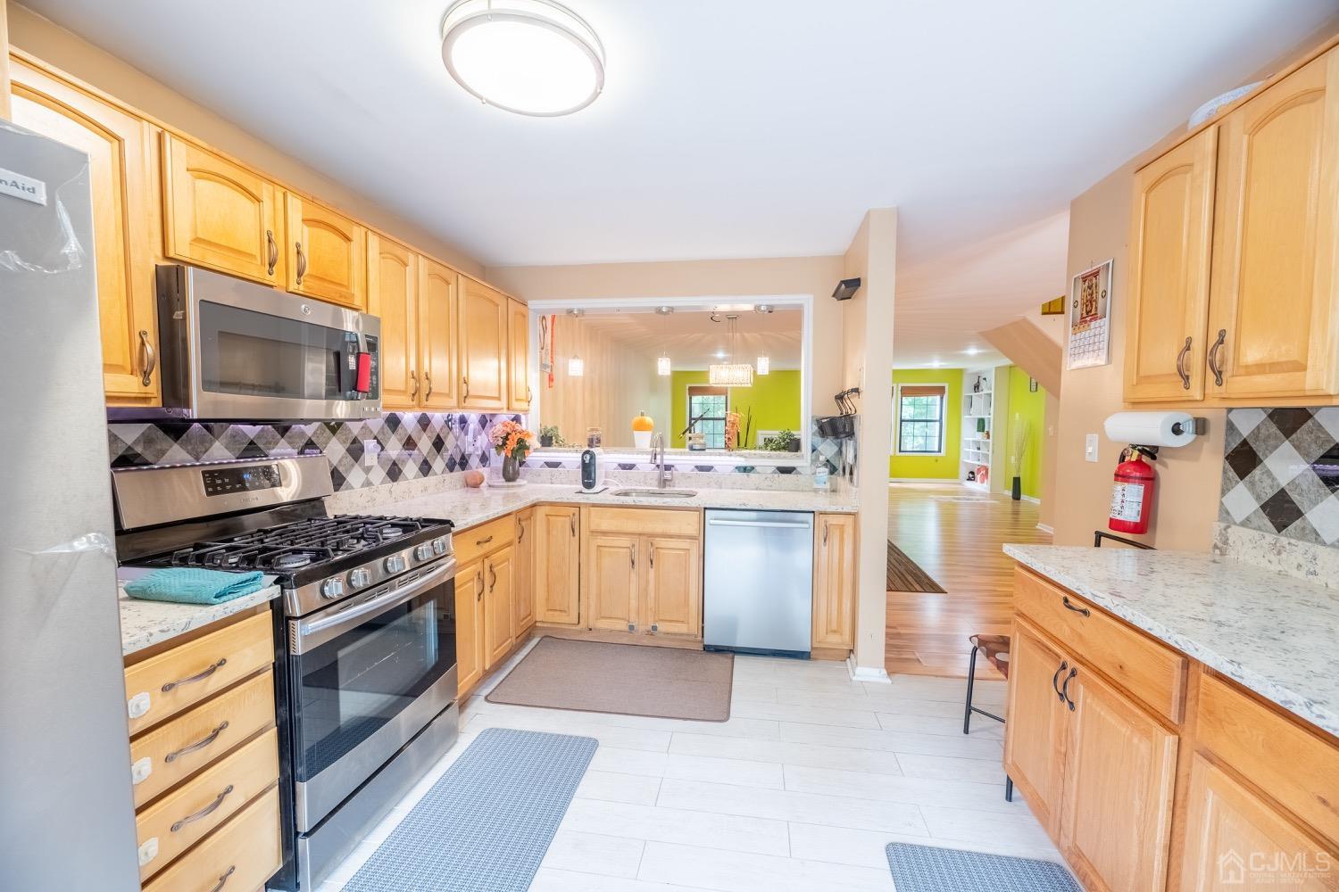 4602 Stonehedge Road Edison, NJ 08820 - Photo 41 of 87 a kitchen with stainless steel appliances granite countertop a stove a sink and a microwave