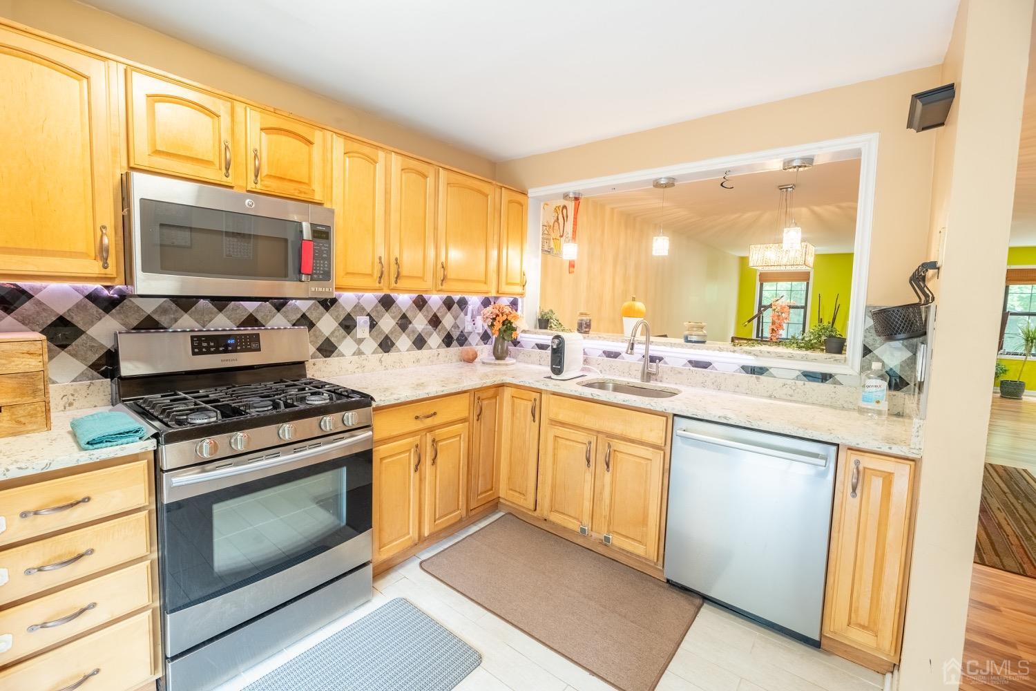 4602 Stonehedge Road Edison, NJ 08820 - Photo 42 of 87 a kitchen with stainless steel appliances granite countertop a stove a sink and a microwave